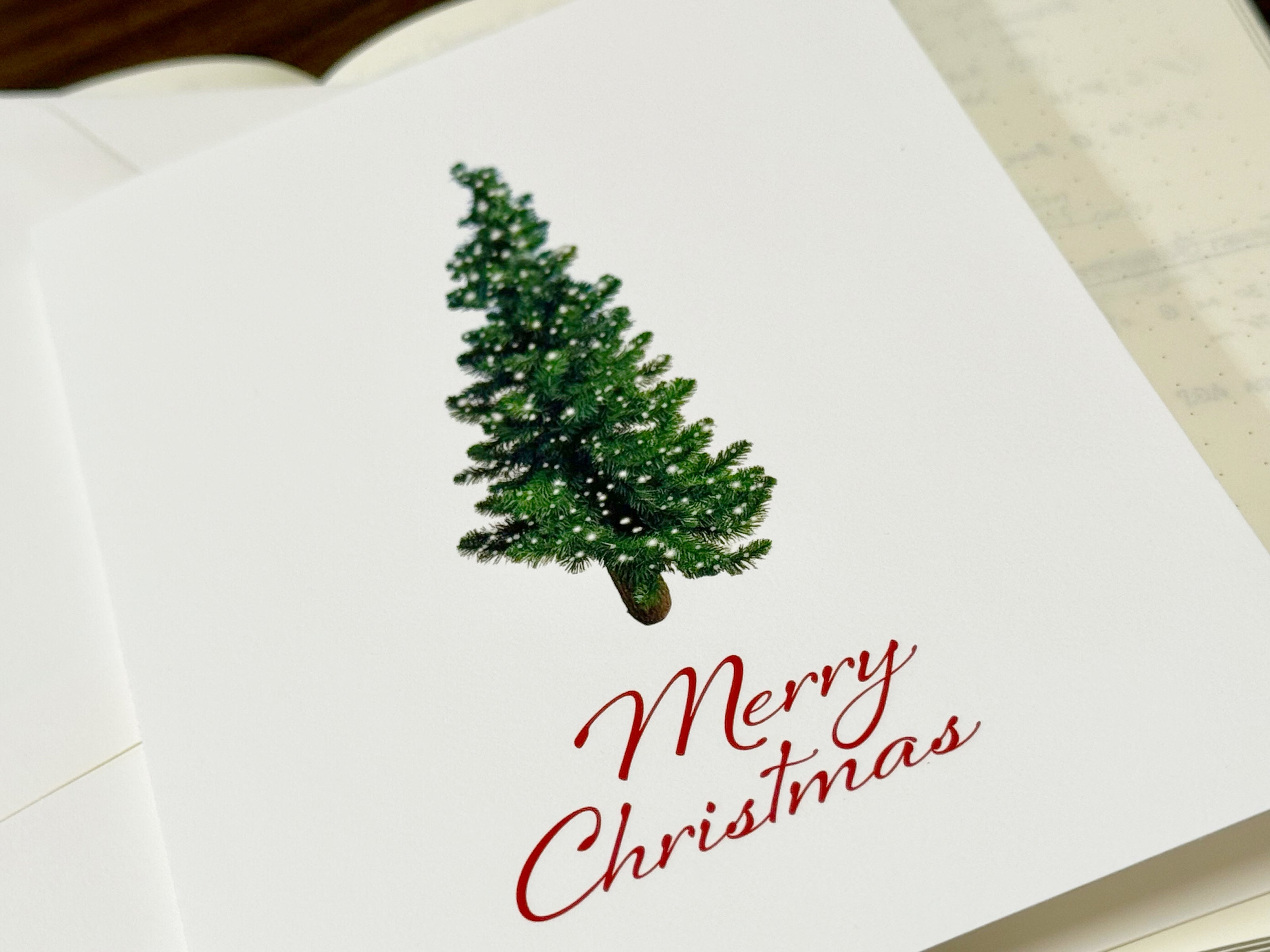 Christmas card with a green tree and 'Merry Christmas' text on a white background